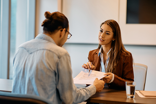 woman showing male coworker something on a piece of paper