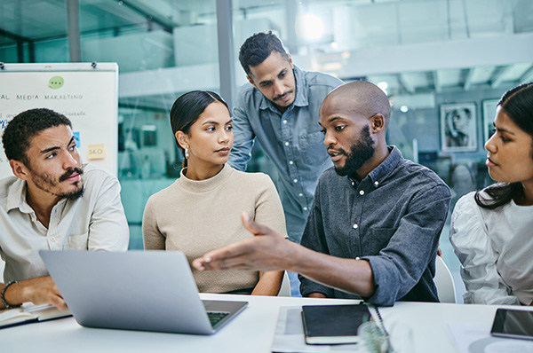 Coworkers holding meeting over laptop