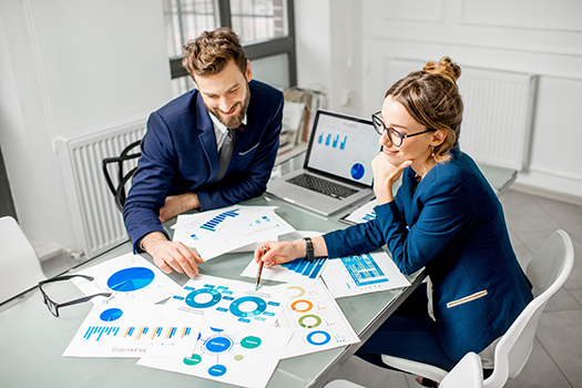 Man and woman looking at data on graphs together