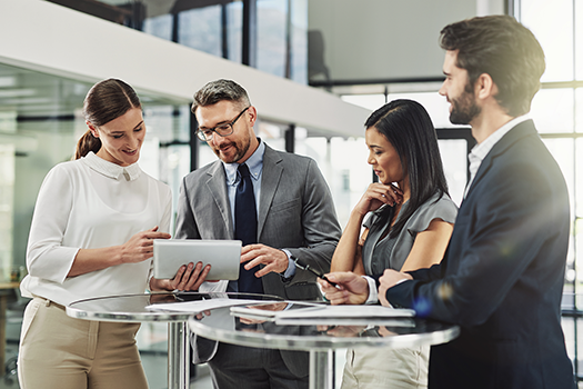 Professional workers gathered around a tablet in office