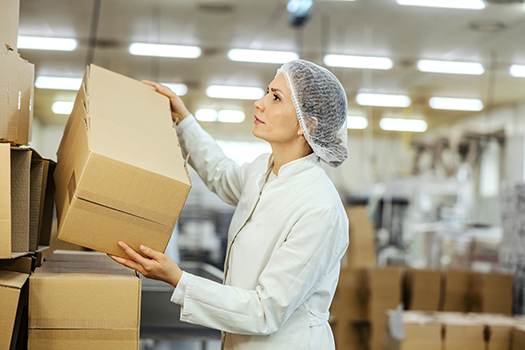 woman stacking boxes in distribution center