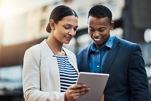 Man and woman colleagues looking at tablet