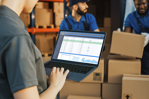 person working on laptop at warehouse
