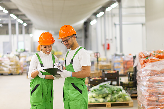 man and woman in food warehouse looking at tablet